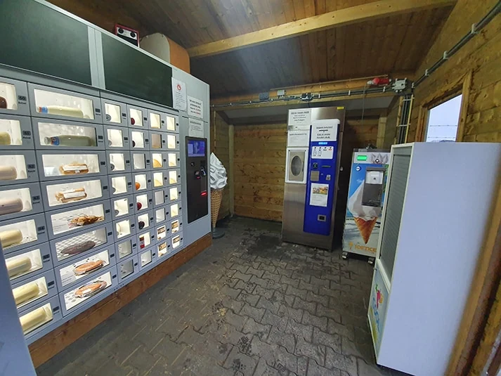 De gevulde verkoopautomaat en melktap in de houten boerderijwinkel